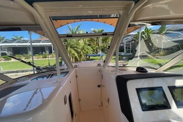 Slide: The Image of 2021 Grady-White Freedom 325 boat interior with navigation screens and outdoor view. - 72