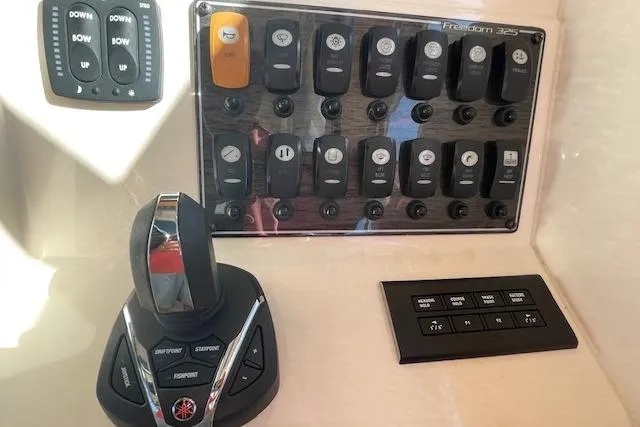 Slide: The Image of Control panel of 2021 Grady-White Freedom 325 boat with switches and throttle. - 46