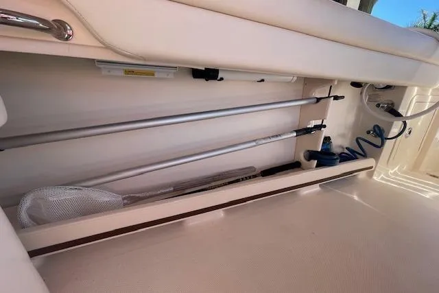 Slide: The Image of Storage compartment in a 2021 Grady-White Freedom 325 boat, featuring fishing gear and equipment. - 37