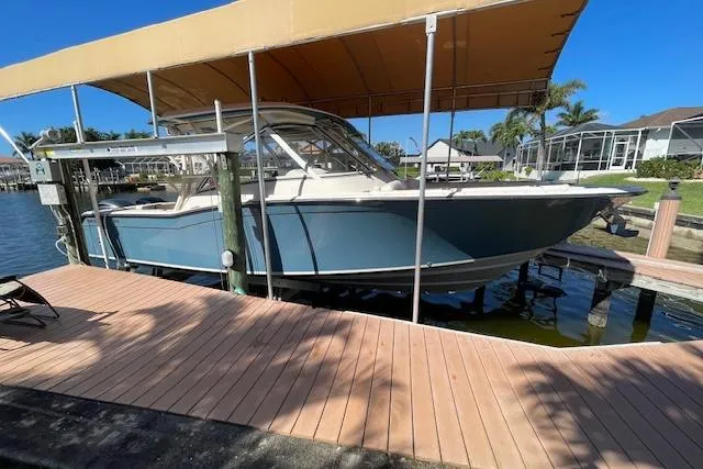Slide: The Image of 2021 Grady-White Freedom 325 boat docked under a canopy on a sunny day. - 103