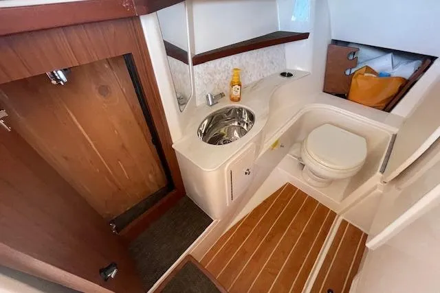 Slide: The Image of 2021 Grady-White Freedom 325 boat bathroom with sink, toilet, and wooden accents. - 54