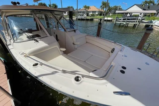 Slide: The Image of 2021 Grady-White Freedom 325 boat docked, showcasing spacious seating and sleek design. - 13