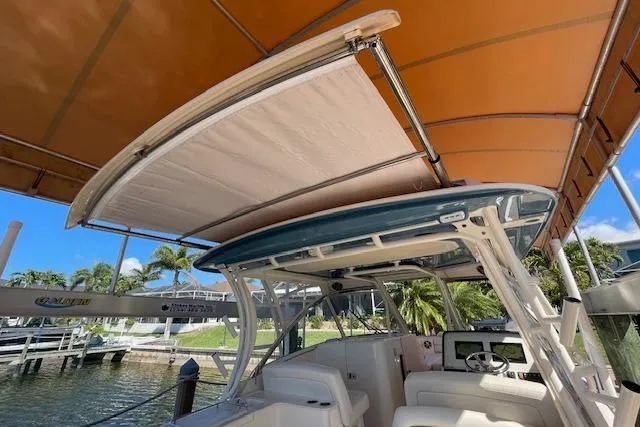 Slide: The Image of 2021 Grady-White Freedom 325 boat with canopy, docked under a marina roof. - 87