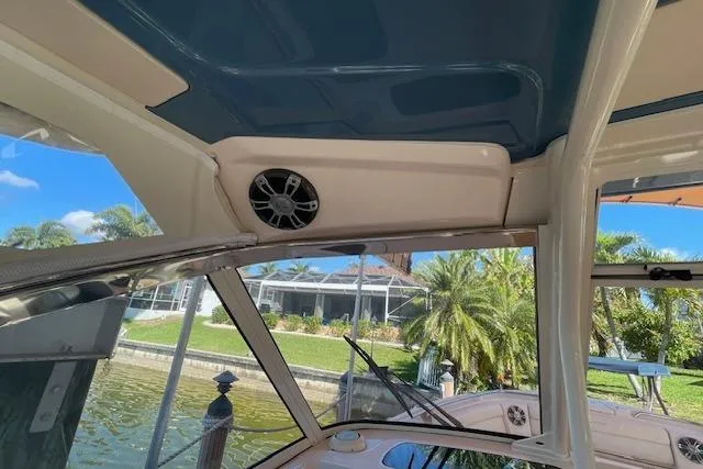 Slide: The Image of 2021 Grady-White Freedom 325 boat interior with speaker, docked near lush greenery. - 73