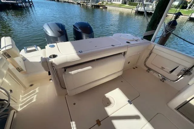 Slide: The Image of 2021 Grady-White Freedom 325 boat interior with seating and twin engines docked by the water. - 32