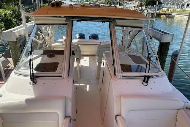 Slide: The Image of 2021 Grady-White Freedom 325 boat docked, showcasing spacious deck and dual engines. - 82