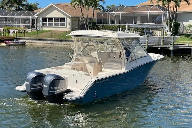 Slide: The Image of 2021 Grady-White Freedom 325 boat with dual Yamaha engines on a sunny waterfront. - 3