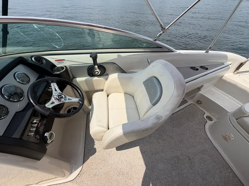 Slide: The Image of The image shows the cockpit of a 2009 Sea Ray 230 Sundeck with a sleek steering wheel and comfortable seating. - 12