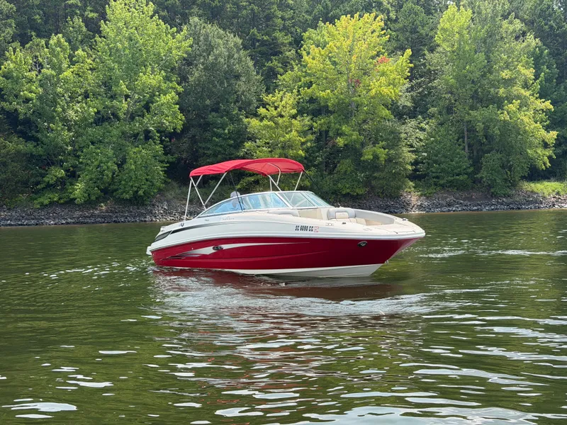 Slide: The Image of A red 2009 Sea Ray 230 Sundeck boat on a calm lake, surrounded by trees. - 5