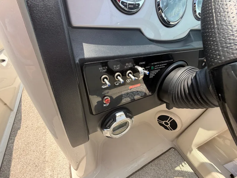 Slide: The Image of Close-up of the helm of a 2009 Sea Ray 230 Sundeck with switches and gauges. - 11
