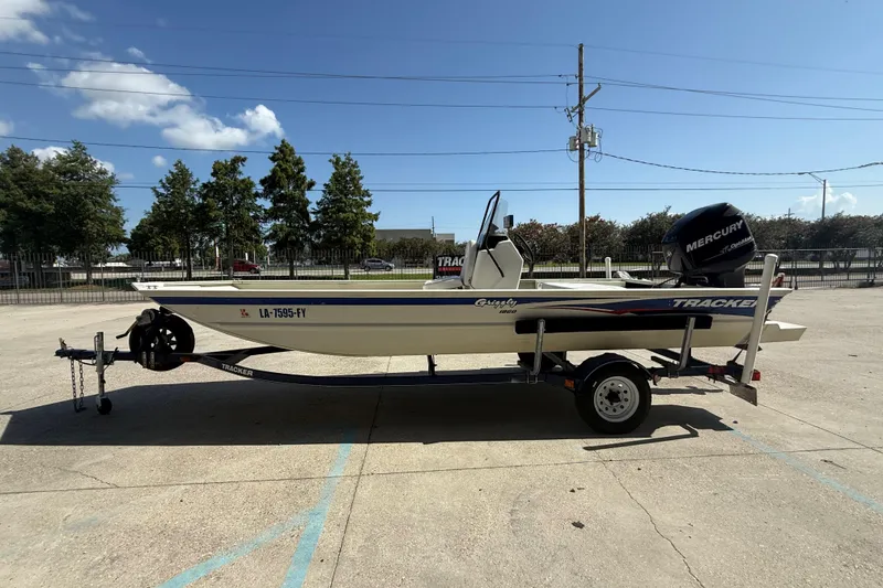 Slide: The Image of 2010 Tracker Grizzly 1860 SC Blind Duck Edition boat on trailer, parked outdoors. - 6
