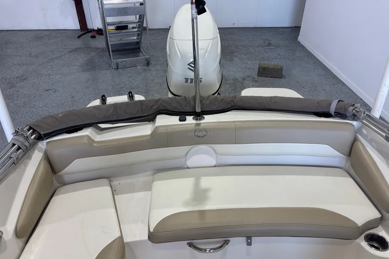 Slide: The Image of 2017 Stingray 182 SC boat interior with seating and motor, in a garage setting. - 9