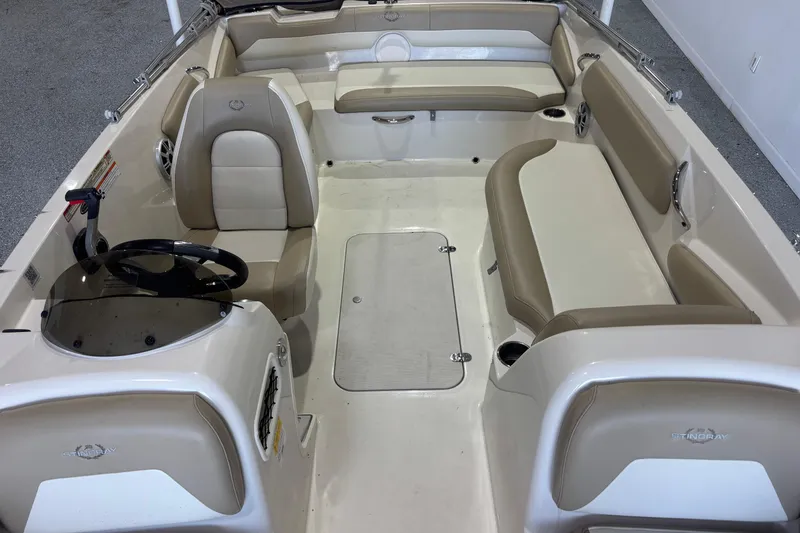 Slide: The Image of 2017 Stingray 182 SC boat interior with beige seating and steering console. - 5