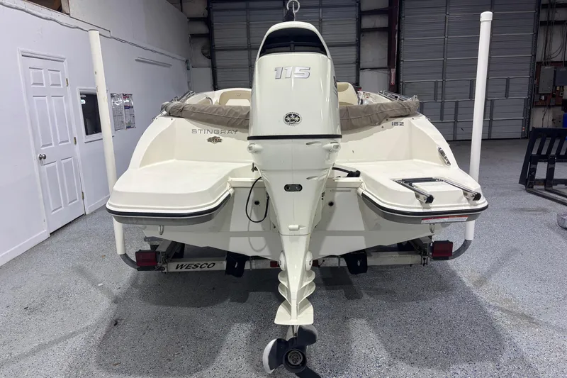 Slide: The Image of 2017 Stingray 182 SC boat with outboard motor in a garage setting. - 4