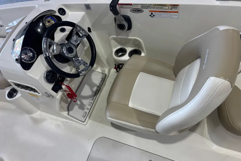 Slide: The Image of 2017 Stingray 182 SC boat cockpit with steering wheel and beige seat. - 8