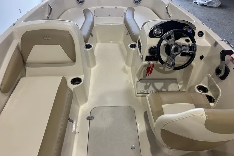 Slide: The Image of 2017 Stingray 182 SC boat interior with beige seating and modern steering console. - 6