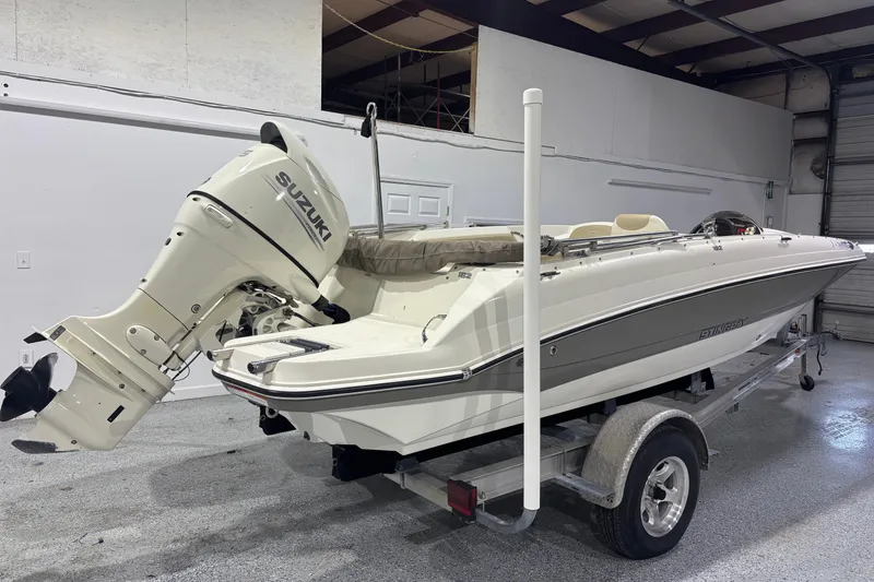 Slide: The Image of 2017 Stingray 182 SC boat with Suzuki outboard motor on trailer in garage. - 3