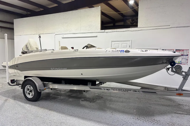 The Image of 2017 Stingray 182 SC boat on trailer in indoor showroom. - 0