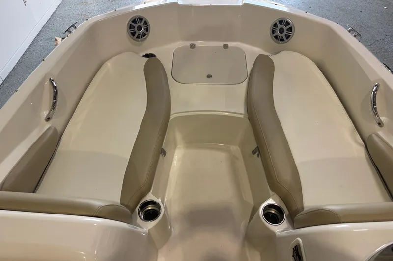 Slide: The Image of 2017 Stingray 182 SC boat interior with beige seating and cup holders. - 7