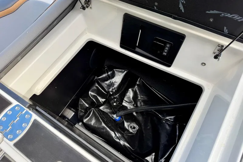 Slide: The Image of Storage compartment of 2025 Tigé Ultré 25ZX boat with black interior and control panel. - 46