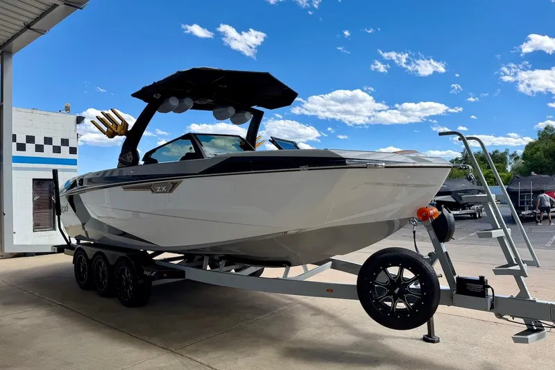 Slide: The Image of 2025 Tigé Ultré 25ZX boat on trailer under clear blue sky. - 9
