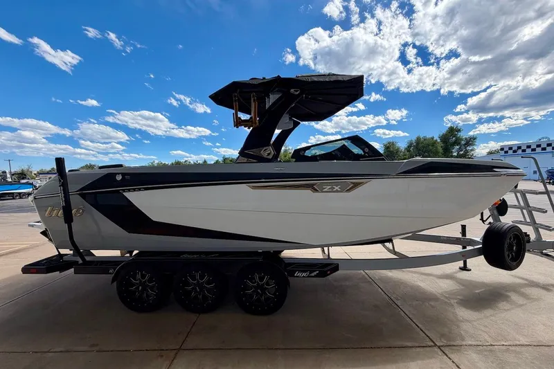Slide: The Image of 2025 Tigé Ultré 25ZX boat on trailer under blue sky with clouds. - 8
