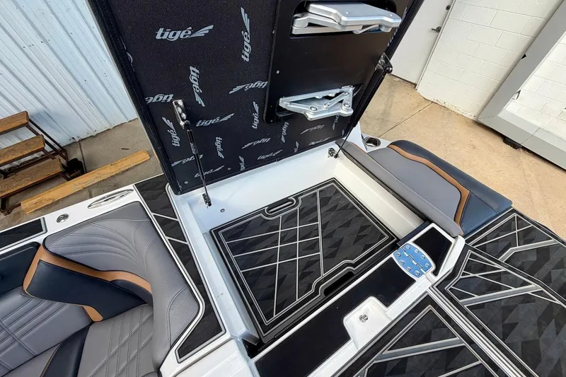 Slide: The Image of 2025 Tigé Ultré 25ZX boat interior with open storage compartment and stylish seating. - 45