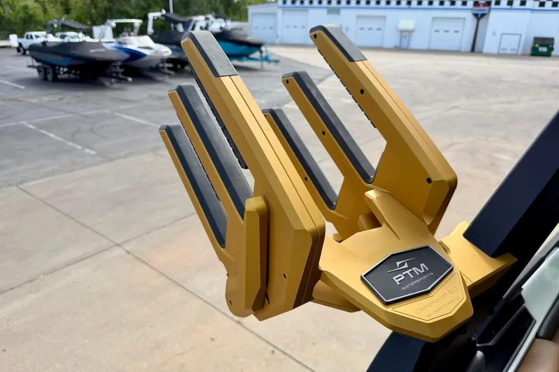 Slide: The Image of Golden PTM Watersports rack on 2025 Tigé Ultré 25ZX boat, with other boats in background. - 49