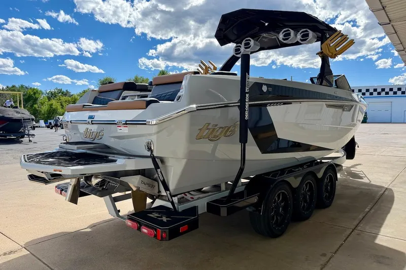 Slide: The Image of 2025 Tigé Ultré 25ZX boat on trailer, sleek design, sunny day, outdoor setting. - 7