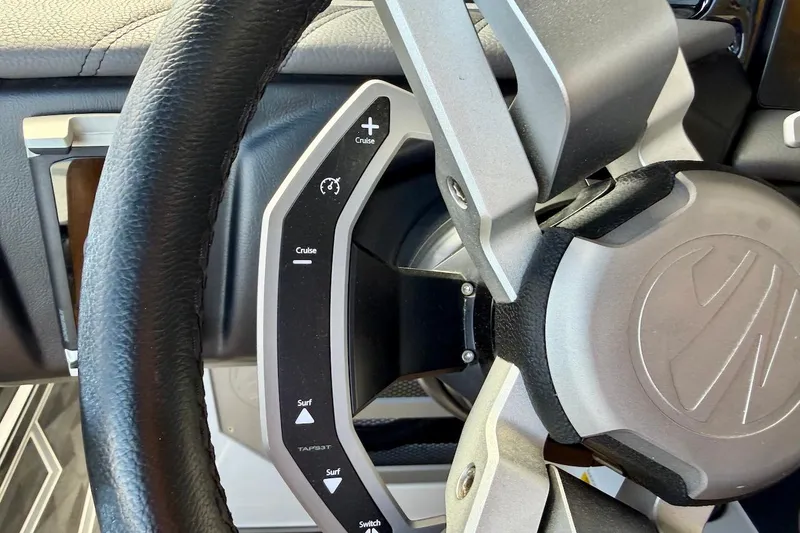 Slide: The Image of Steering wheel of 2025 Tigé Ultré 25ZX boat with cruise control and surf settings. - 37