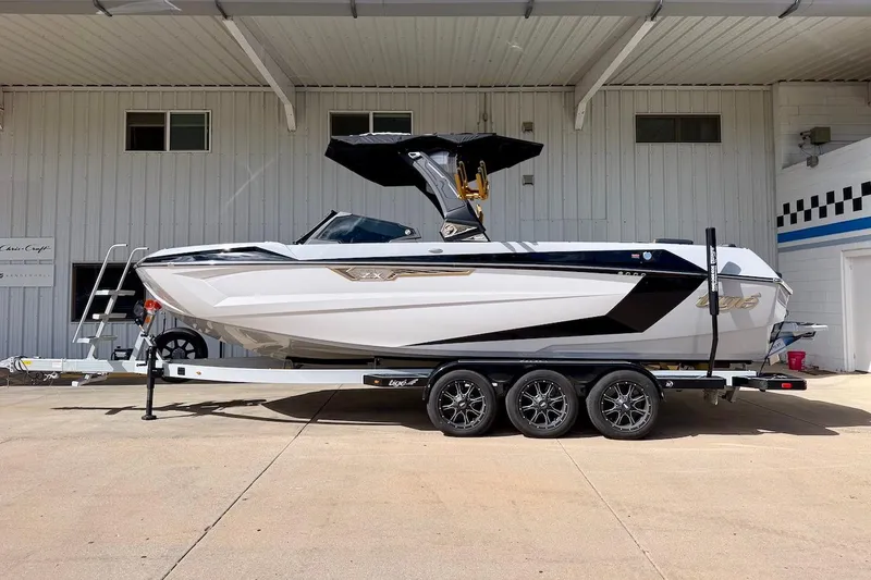 The Image of 2025 Tigé Ultré 25ZX boat on trailer, parked outside a building. - 1