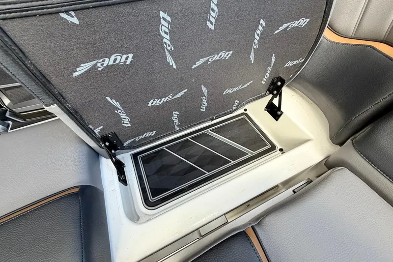 Slide: The Image of 2025 Tigé Ultré 25ZX boat interior storage compartment with branded upholstery. - 32