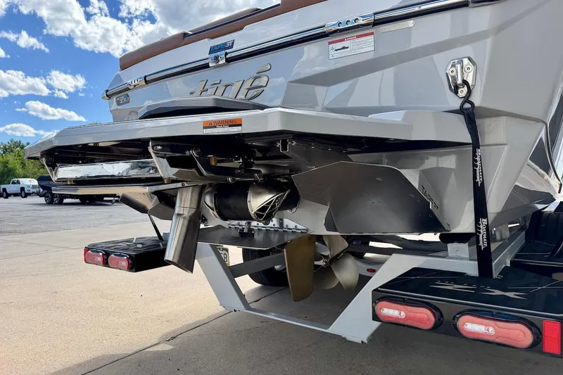 Slide: The Image of 2025 Tigé Ultré 25ZX boat rear view, showcasing propeller and exhaust system under a clear sky. - 6