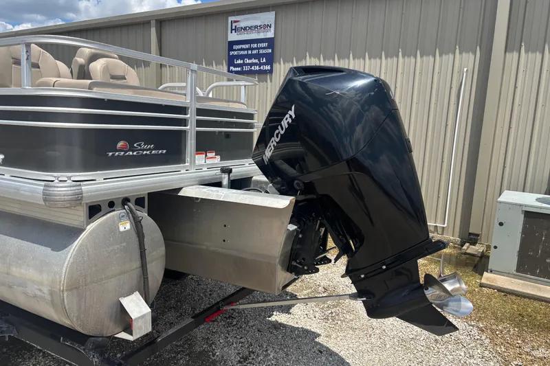 Slide: The Image of 2020 Sun Tracker Fishin' Barge 22 XP3 with Mercury outboard motor, parked outdoors. - 2