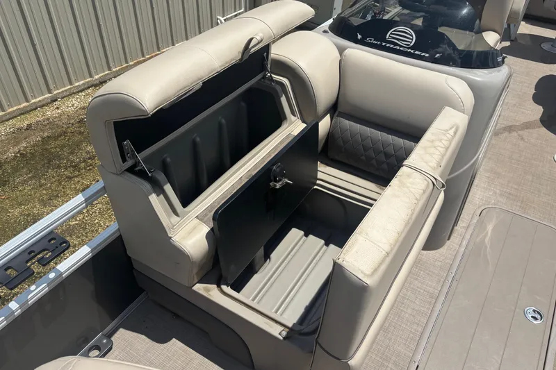 Slide: The Image of 2020 Sun Tracker Fishin' Barge 22 XP3 boat seat storage compartment open. - 8