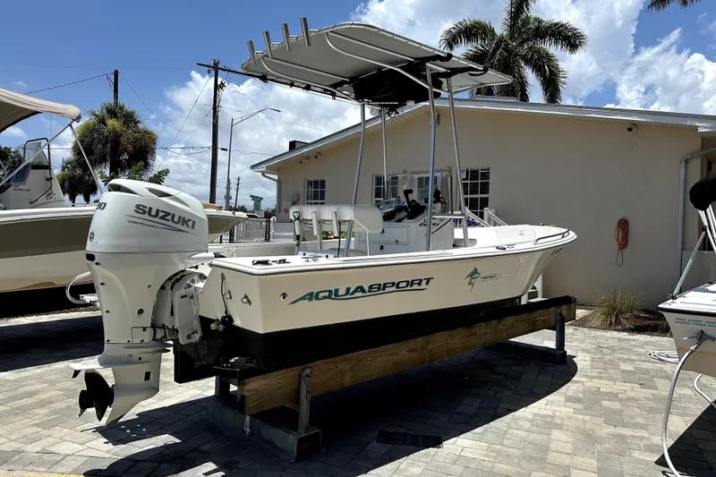 Slide: The Image of 2004 Aquasport 175 Osprey boat with Suzuki outboard motor, parked outdoors. - 4