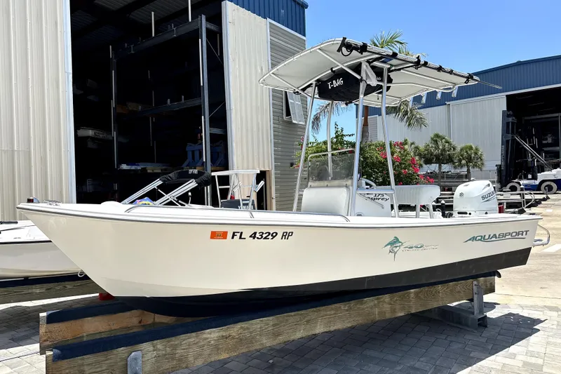 The Image of 2004 Aquasport 175 Osprey boat on display, featuring a sleek design and Suzuki outboard motor. - 1