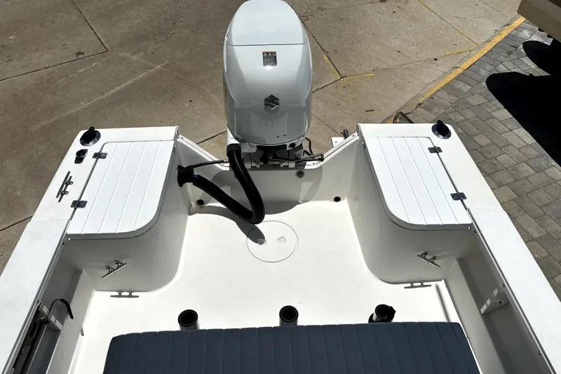 Slide: The Image of 2004 Aquasport 175 Osprey boat interior with outboard motor, featuring storage compartments. - 11