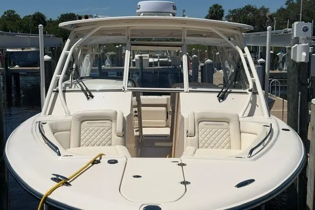 Slide: The Image of 2024 Grady-White Freedom 335 boat docked, showcasing spacious seating and sleek design. - 5