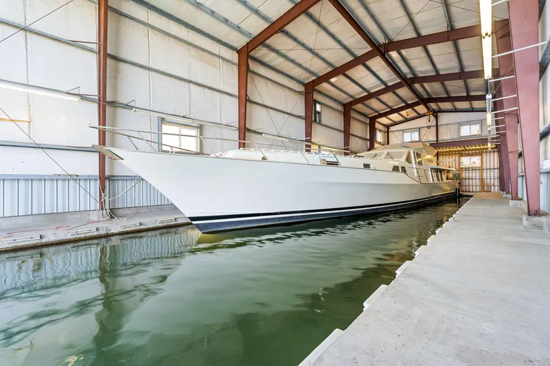 Slide: The Image of Custom 1985 Larson Boathouse with large boat docked inside spacious indoor facility. - 15