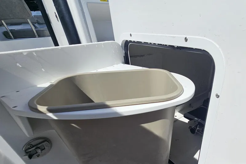 Slide: The Image of Storage compartment with trash bin on 2027 Sea Hunt Ultra 245 SE boat. - 15