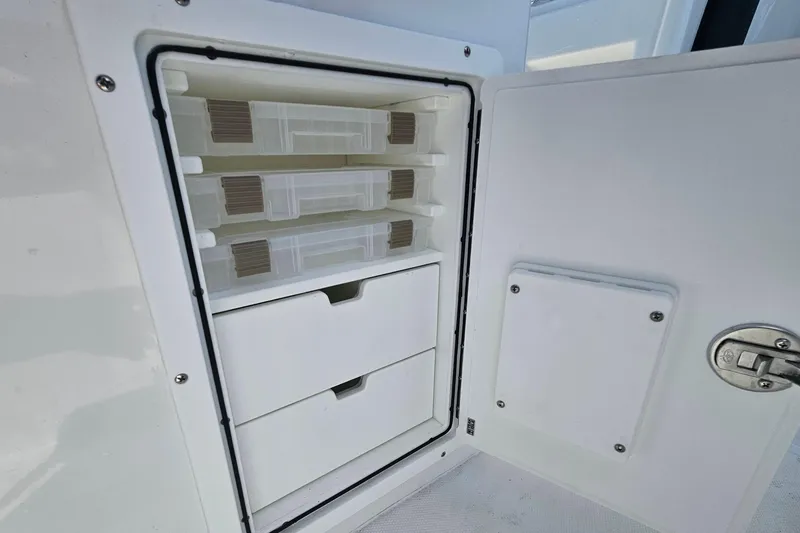 Slide: The Image of Storage compartment with drawers on a 2027 Sea Hunt Ultra 245 SE boat. - 14