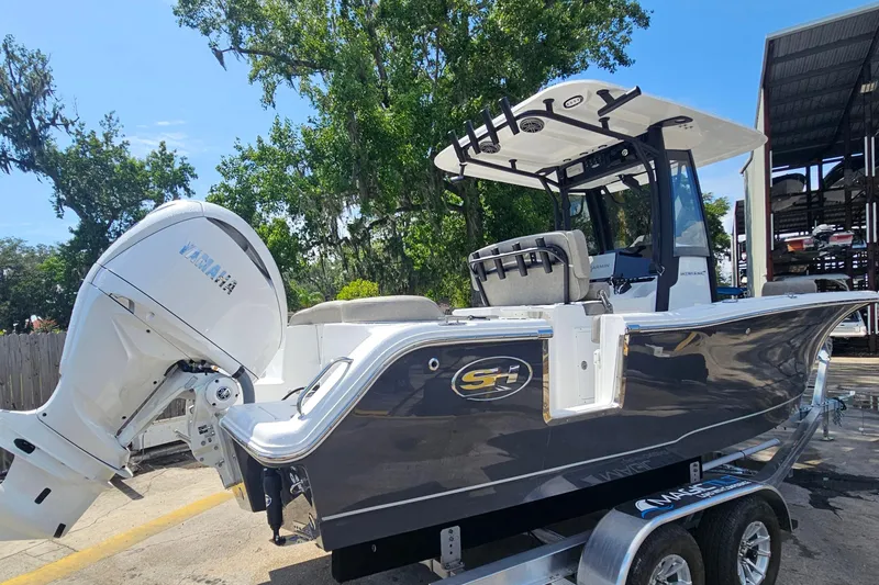 Slide: The Image of 2027 Sea Hunt Ultra 245 SE boat with Yamaha engine on trailer, parked outdoors. - 5
