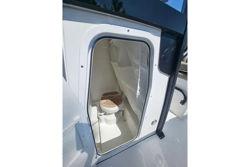 Slide: The Image of 2027 Sea Hunt Ultra 245 SE boat interior with compact marine toilet. - 23