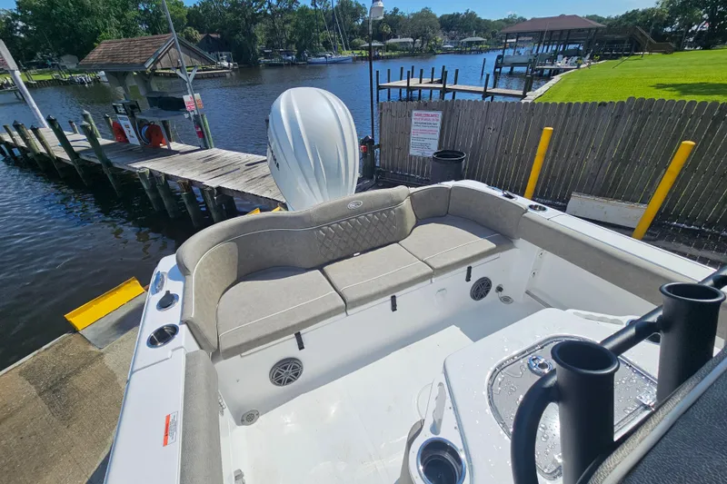 Slide: The Image of 2027 Sea Hunt Ultra 245 SE boat docked by a serene waterfront. - 29