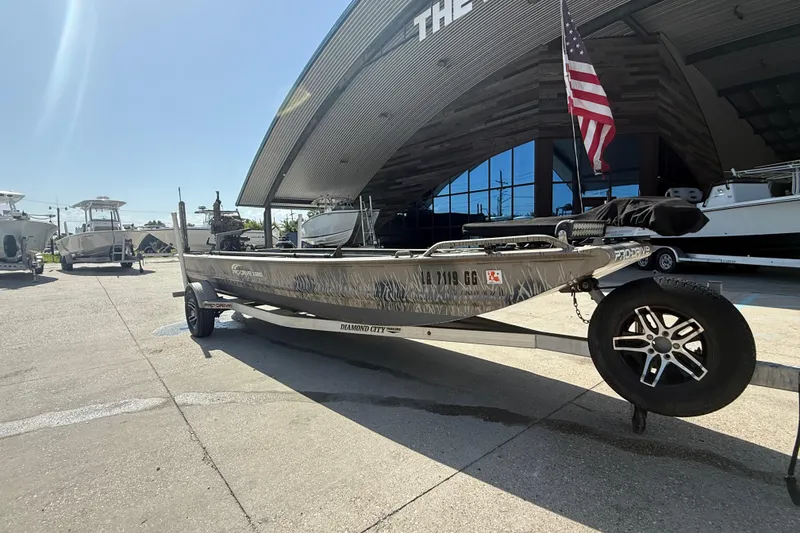 Slide: The Image of 2017 Pro-Drive 2048 boat on trailer, parked outside a showroom with an American flag. - 4