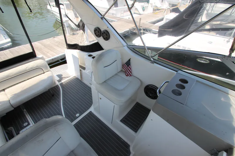 Slide: The Image of 1999 Bayliner 3055 Ciera boat interior with seating, cup holders, and American flag. - 14