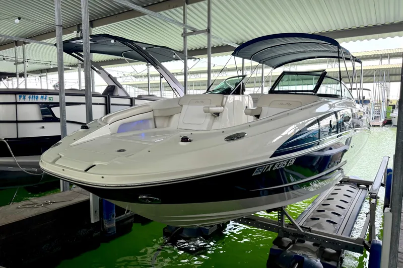 Slide: The Image of 2013 Sea Ray 260 Sundeck boat docked in a covered marina. - 10