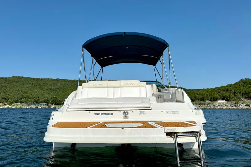 Slide: The Image of 2013 Sea Ray 260 Sundeck boat with canopy on a serene lake. - 4