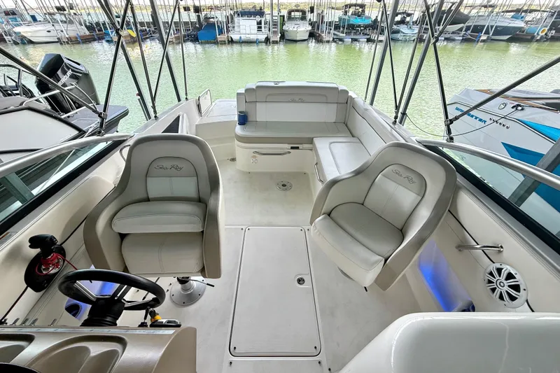 Slide: The Image of 2013 Sea Ray 260 Sundeck interior with plush seating and helm, docked at marina. - 17